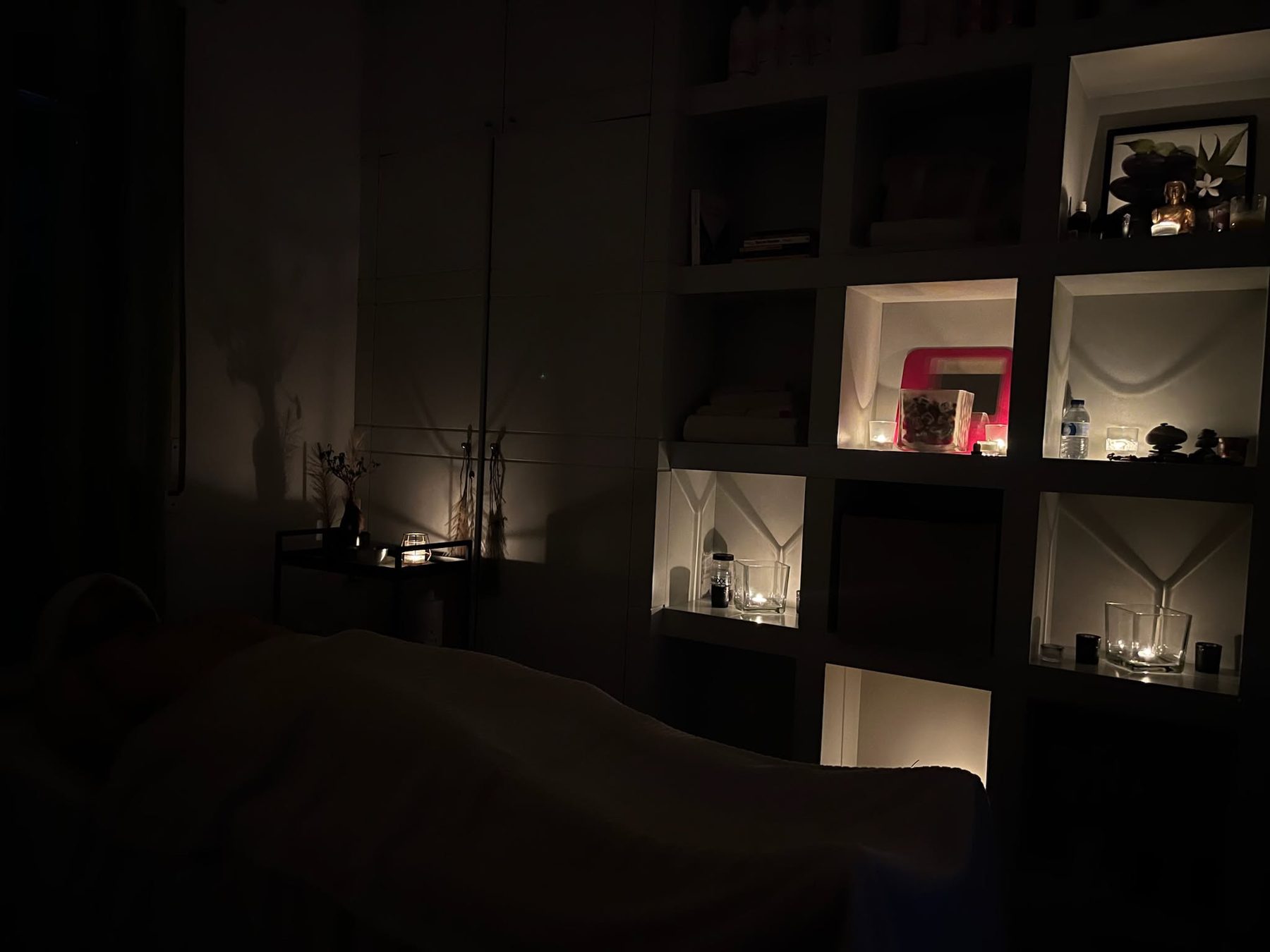 The studio at night, lit by candles on open shelves